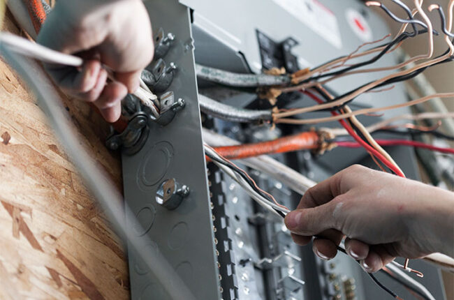 Homme répare un panneau électrique